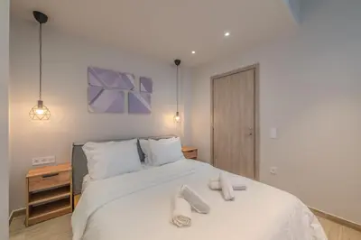 a bedroom with a large white bed with two towels on it at Minimal Style Apartment in Piraeus