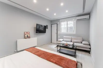 a white bedroom with a bed and a couch at Acropolis Nest in Athens