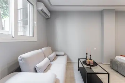 a living room with a white couch and a table at Acropolis Nest in Athens