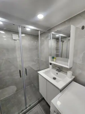 a white bathroom with a shower and a sink at Kallithea VIP Apartments in Athens