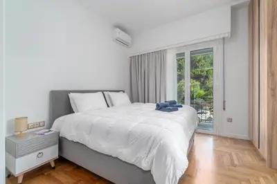 a white bedroom with a large bed and a window at Urban Nest 1 in Athens