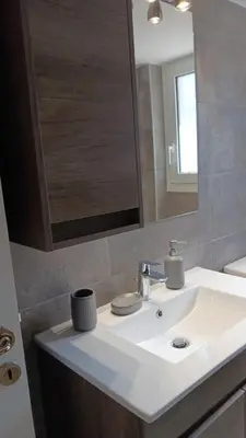 a bathroom with a white sink and a mirror at Adorable apartment in Athens
