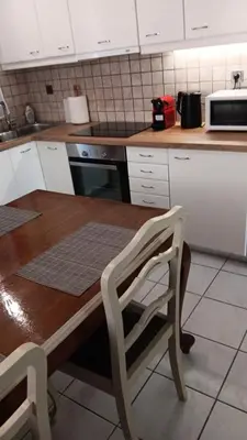 a kitchen with a wooden table and a chair at Adorable apartment in Athens