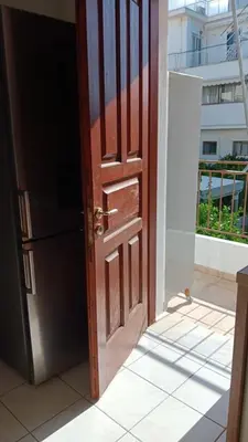 an open wooden door with a view of a building at Adorable apartment in Athens