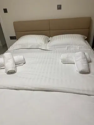 a large white bed with two towels on it at Adorable apartment in Athens