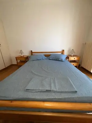 a bedroom with a bed with a blue comforter at The Kallimarmaro Nest in Athens