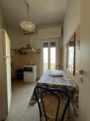 a small kitchen with a table and a refrigerator at The Kallimarmaro Nest in Athens
