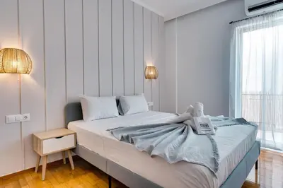 a bedroom with a bed with a blue blanket on it at Relax in Style Petralona Modern Flat in Athens