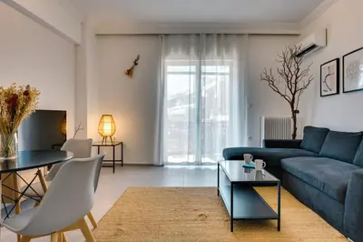 a living room with a blue couch and a table at Relax in Style Petralona Modern Flat in Athens