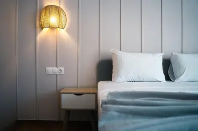 a bedroom with a bed with a lamp and a side table at Relax in Style Petralona Modern Flat in Athens