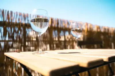 two wine glasses sitting on top of a wooden table at Relax in Style Petralona Modern Flat in Athens