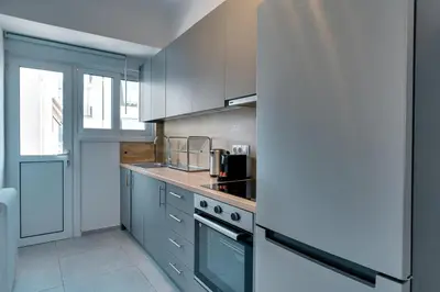 a kitchen with gray cabinets and a stove top oven at Relax in Style Petralona Modern Flat in Athens
