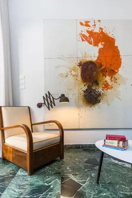 a chair and a table in a room with a painting at Elegant Private Home by the Acropolis in Athens