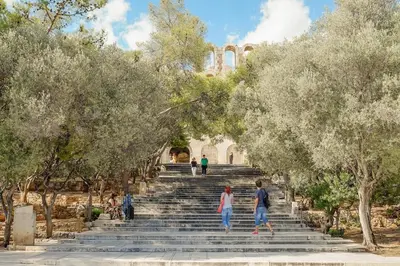 a group of people walking up a set of stairs with trees at Elegant Private Home by the Acropolis in Athens
