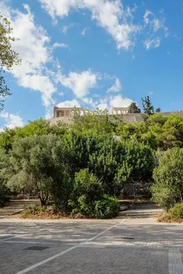 a parking lot with trees and a building on a hill at Elegant Private Home by the Acropolis in Athens
