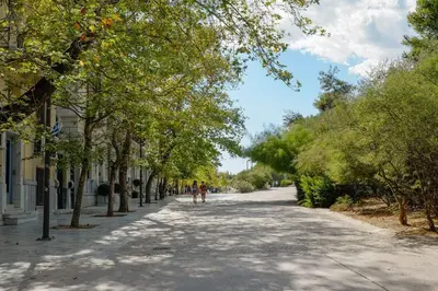 a tree lined street with people walking down it at Elegant Private Home by the Acropolis in Athens