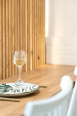 a glass of wine sitting on a wooden table at Central Modern Studio with balcony,1 min to Metro,10 min to Acropolis in Athens