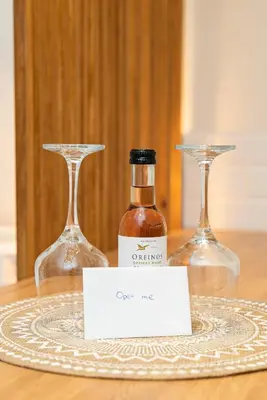 two wine glasses and a bottle on a table at Central Modern Studio with balcony,1 min to Metro,10 min to Acropolis in Athens