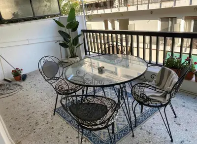 a glass table and chairs on a balcony at Iris 2 Bedroom with Balcony in Pagkrati in Athens
