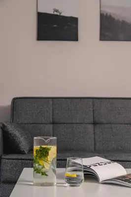a table with two glasses and a book on it at Athens Neos Kosmos 1BDR apt near to metro station in Athens