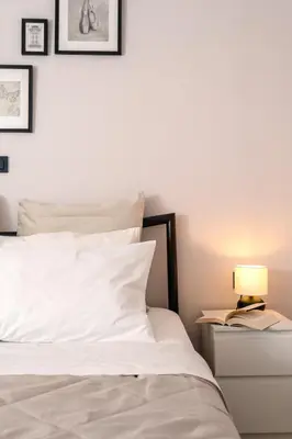 a bed with white sheets and a lamp on a night stand at Athens Neos Kosmos 1BDR apt near to metro station in Athens