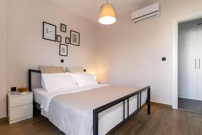 a bedroom with a large bed with white sheets at Athens Neos Kosmos 1BDR apt near to metro station in Athens