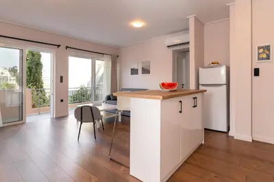 a kitchen with a white refrigerator and a table at Athens Neos Kosmos 1BDR apt near to metro station in Athens