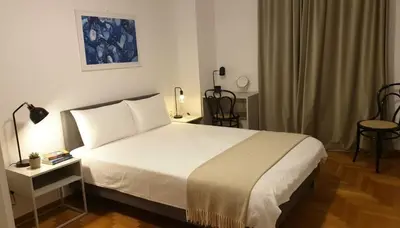 a bedroom with a white bed and a table and chairs at Urban Soul Modern 2BR Retreat in Exarcheia in Athens