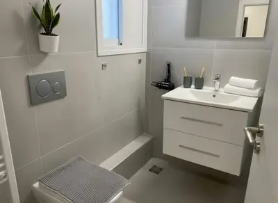 a white bathroom with a sink and a toilet at Urban Soul Modern 2BR Retreat in Exarcheia in Athens