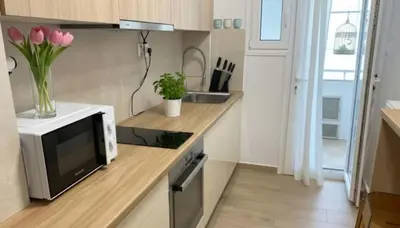 a kitchen with a microwave and a vase of flowers at Urban Soul Modern 2BR Retreat in Exarcheia in Athens