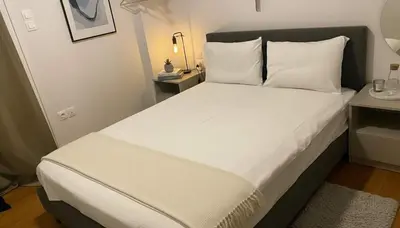 a bed with white sheets and pillows in a room at Urban Soul Modern 2BR Retreat in Exarcheia in Athens
