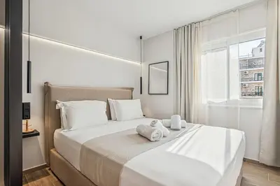a bedroom with a large white bed with towels on it at The Athens Luminous Suite in Athens
