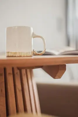 a coffee cup sitting on top of a wooden table at The Athens Luminous Suite in Athens