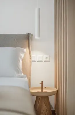 a bed with a cross on a table next to it at The Athens Solstice Suite in Athens