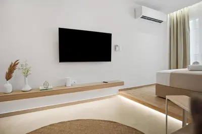 a living room with a television on a white wall at The Athens Solstice Suite in Athens