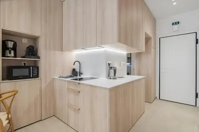 a kitchen with wooden cabinets and a sink and a microwave at The Athens Solstice Suite in Athens