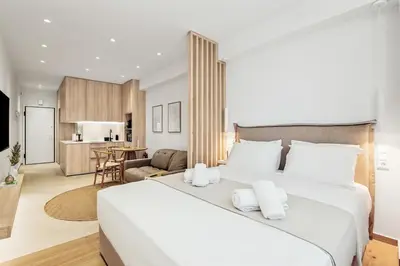 a bedroom with a large white bed and a living room at The Athens Edit Suite in Athens
