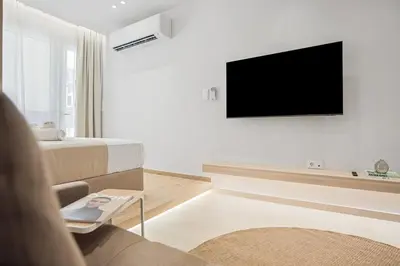 a living room with a couch and a tv on a wall at The Athens Edit Suite in Athens
