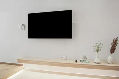 a living room with a tv on a white wall at The Athens Edit Suite in Athens