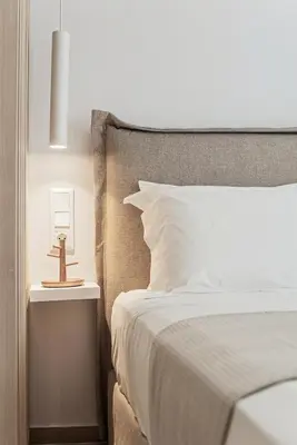 a bedroom with a white bed and a nightstand with a bed sidx sidx sidx at The Athens Edit Suite in Athens