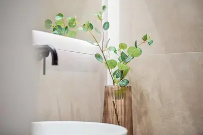 a bathroom with a vase with a plant in it at The Athens Edit Suite in Athens