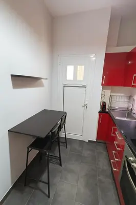 a small kitchen with a black table and red cabinets at Panormou Urban Getaway Next to Metro Fast Wi-Fi in Athens