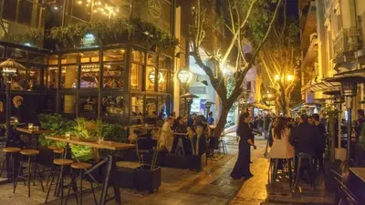 a group of people walking down a street at night at Panormou Urban Getaway Next to Metro Fast Wi-Fi in Athens