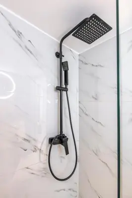 a shower with a black shower head in a bathroom at Aqua Bliss Piraeus in Piraeus