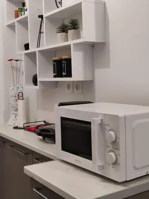 a white kitchen with a microwave on a counter at Urban Cocoon, Nice & Easy in Athens