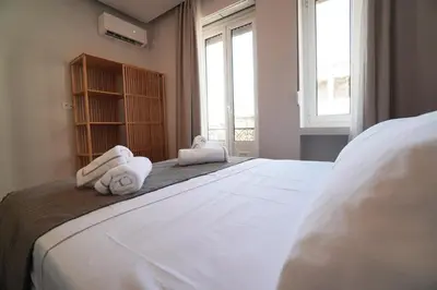 a bedroom with a large white bed with towels on it at Athens Residence Ermou in Athens