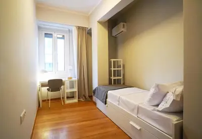 a small bedroom with a bed and a window at Athens Residence Ermou in Athens