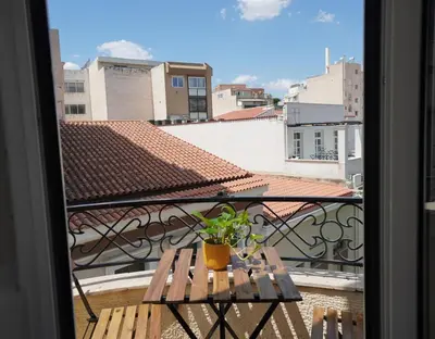 a balcony with a wooden table and a potted plant at Athens Residence Ermou in Athens