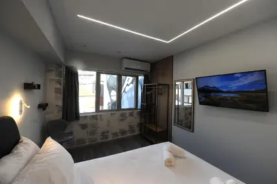 a bedroom with a bed and a tv on the wall at Cozy Loft Monastiraki in Athens