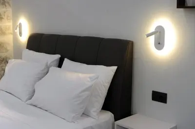 a bed with white pillows and a black head board at Cozy Loft Monastiraki in Athens